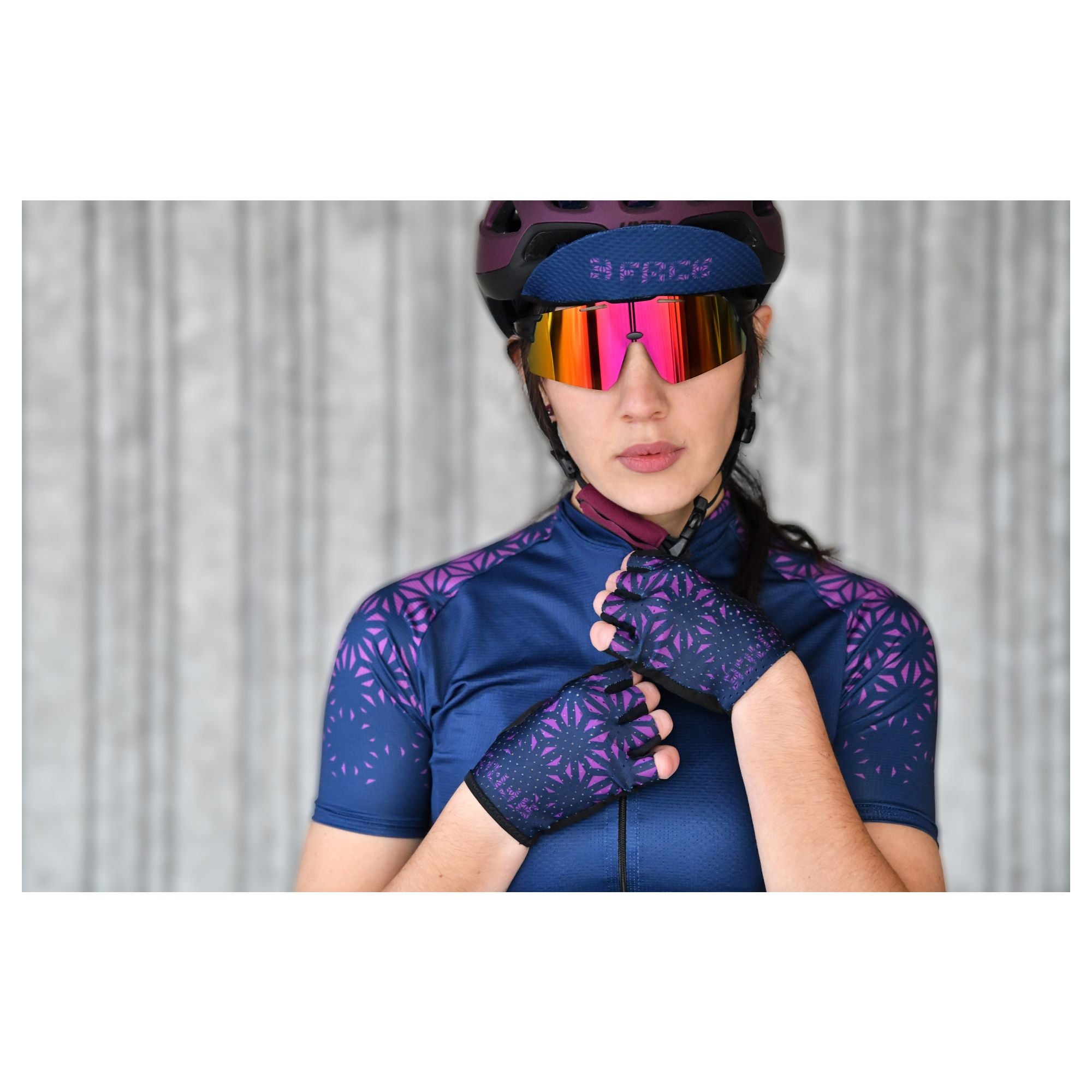 Eine Velofahrerin in kompletter 3face-Rennbekleidung während einer Tour auf offener Strasse. Das enganliegende Trikot und die passende Velohose bieten eine aerodynamische Passform und maximalen Komfort. Ideal für ambitionierte Sportlerinnen.